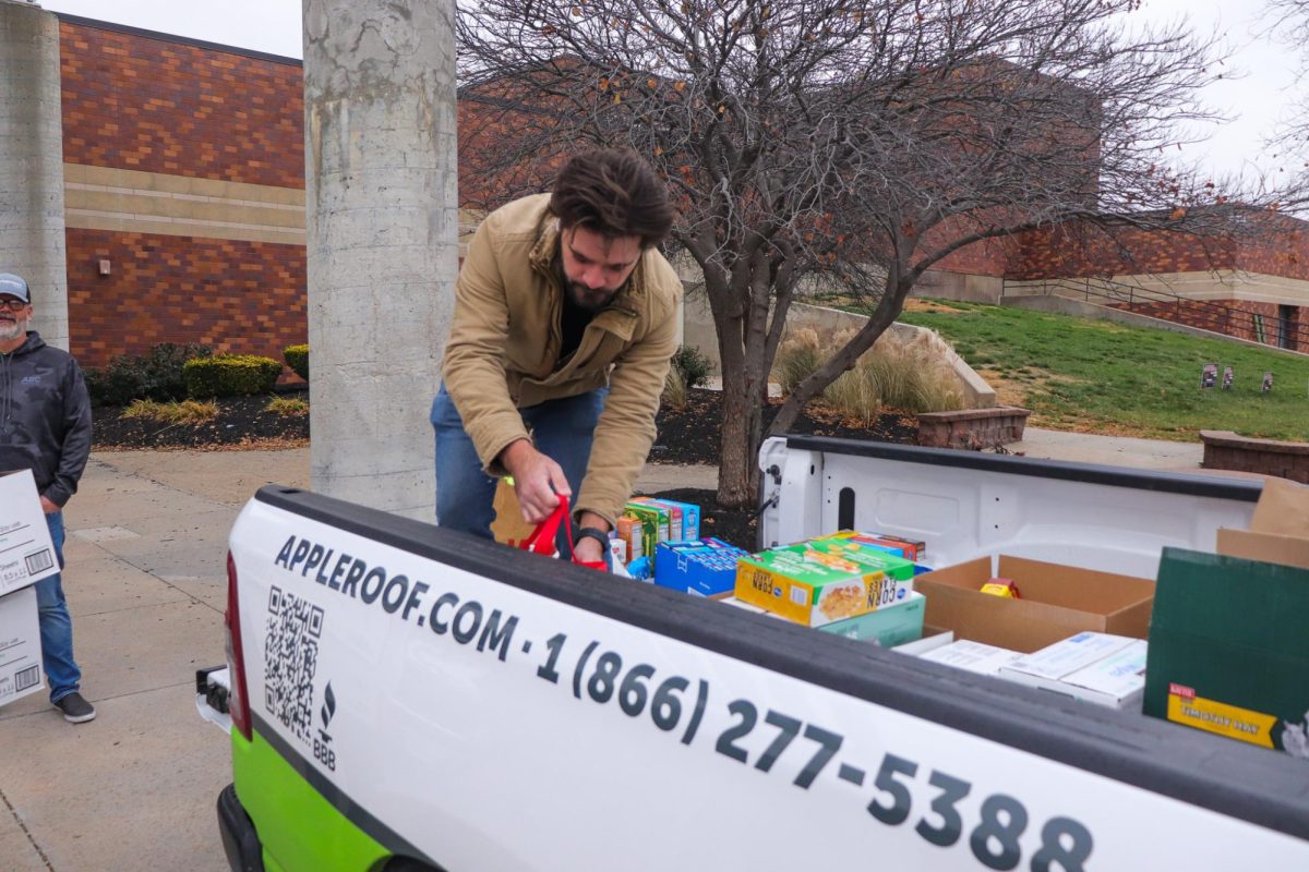 A worker organizing the food in the bed of his truck