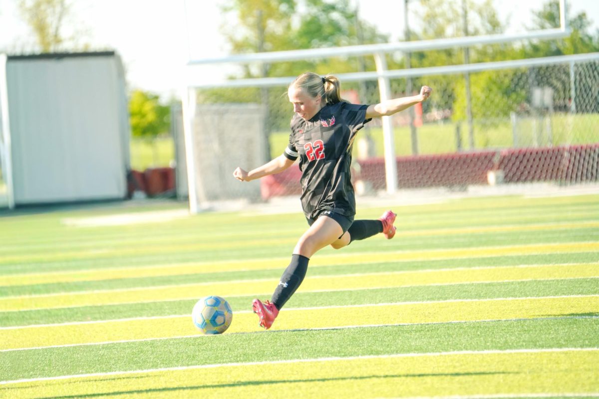 Senior Olivia Thompson kicks the ball up the field to get a shot on net. 