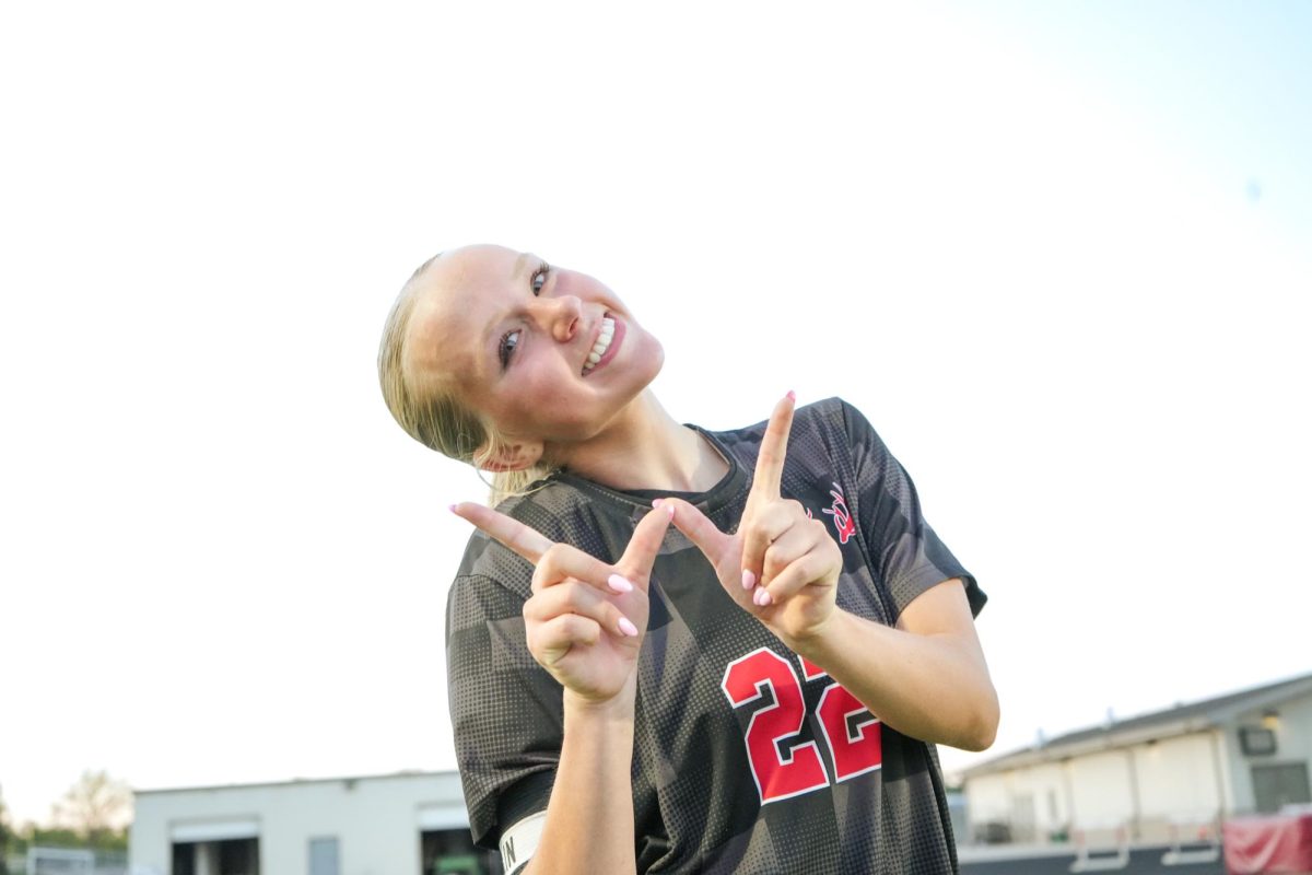 Senior, Olivia Thompson holding up a W after getting player of the game and winning for the Antlers. 