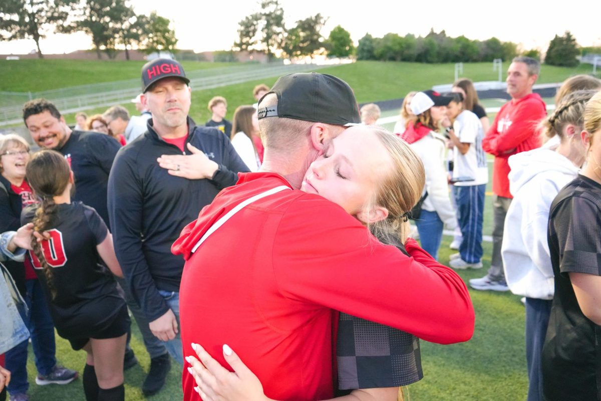 Senior, Olivia Thompson hugging her dad after winning the district championship. 