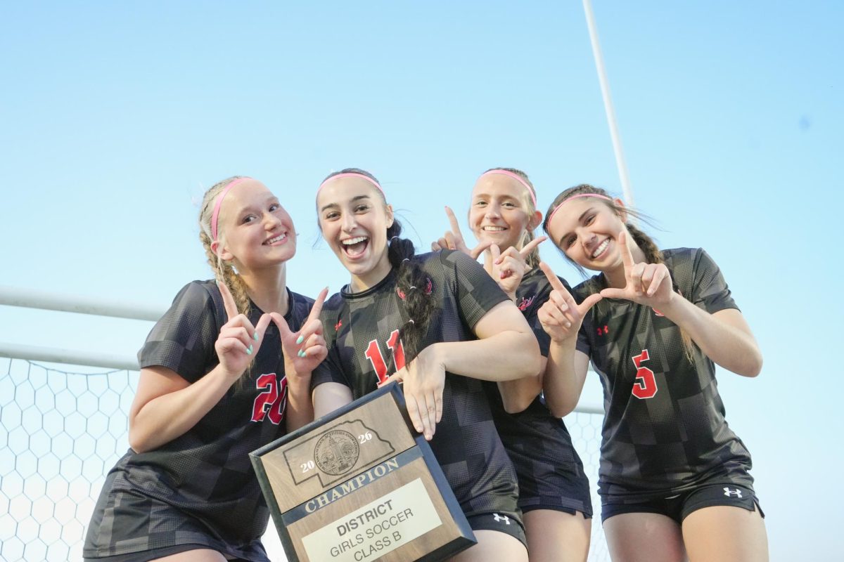 Juniors Lily Larka, Lulu Lary, Brooklyn Ballan, and Molly Flynn holding up a W after winning the district final to advance to the state championship. 