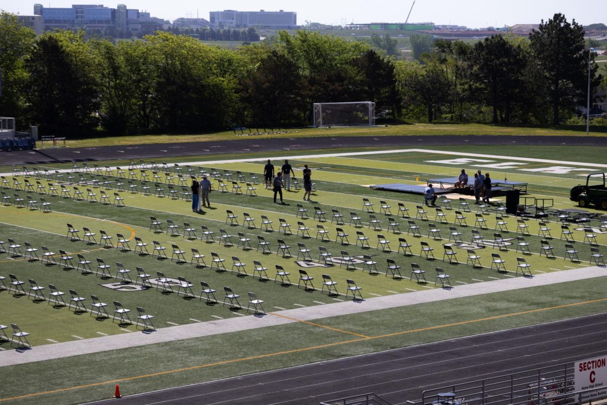 Staff sets up chairs for graduation this Sunday. There is a possibility it will be moved inside due to weather.