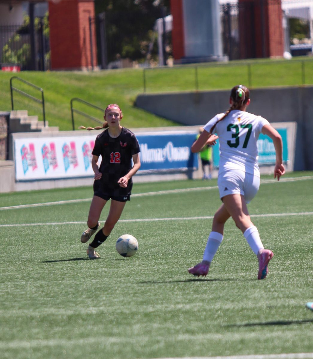Freshman Neeley Harnisch dribbles past a Kearney Catholic player in the first round of the state tournament. The Antlers won 5-0.